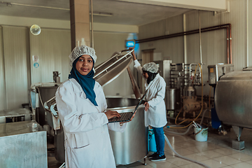 Image showing Arab business partners checking the quality of cheese in the industry and enter data into a laptop. Small business concept