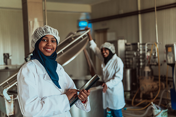 Image showing Arab business partners checking the quality of cheese in the industry and enter data into a laptop. Small business concept