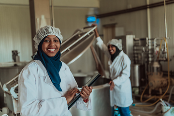 Image showing Arab business partners checking the quality of cheese in the industry and enter data into a laptop. Small business concept