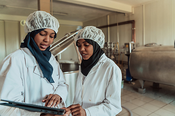 Image showing Arab business partners checking the quality of cheese in the industry and enter data into a laptop. Small business concept