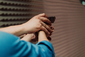 Image showing The trainer explaining to the man how to use the gun. Training in the shooting range