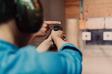 Image showing The trainer explaining to the man how to use the gun. Training in the shooting range