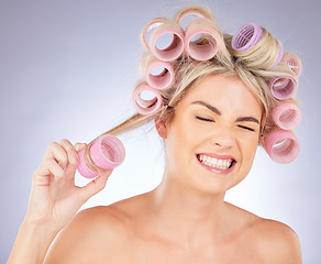 Image showing Woman, hair care and pain with roller for beauty in studio isolated on a white background. Happy, curlers and model with hairstyle for aesthetic, cosmetics and salon treatment for natural growth.