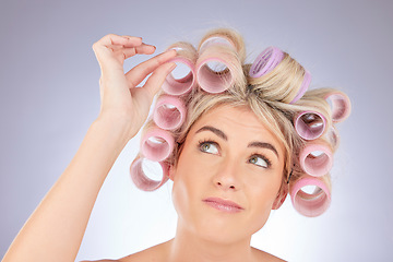 Image showing Hairstyle, roller and woman thinking in a studio doing a natural, healthy and curly hair. Self care, confused and a female model with curler for beauty wellness isolated by a white background.