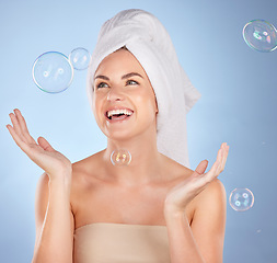 Image showing Happy, studio face and woman with bubbles for skincare, body cleaning bath or morning hygiene wash. Bathroom, beauty happiness or person with smile, wellness or self care hydration on blue background