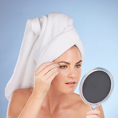 Image showing Beauty, woman and mirror with tweezers for eyebrow in studio, blue background or aesthetic change. Face of female model, epilation tools and hair removal for grooming brows, facial skincare or shower