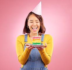 Image showing Birthday cake candle, celebration and Asian woman excited, smile and celebrate party, surprise or studio gift. Event cheers, wow and Japanese person with dessert, candy or sweets on pink background