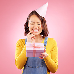 Image showing Birthday present, box and curious Asian woman excited, smile and celebrate party, studio prize or gift. Secret surprise, wonder and Japanese person with mystery event package on pink background