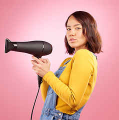 Image showing Hairdryer, beauty and hair care with portrait of woman in studio for hairdresser, salon and cosmetics. Shampoo, spa and hairstyle with face of asian person on pink background for product