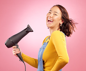 Image showing Hairdryer, funny and hair care with portrait of woman in studio for hairdresser, beauty and cosmetics. Shampoo, smile and hairstyle with asian person laughing on pink background for product and salon