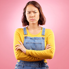 Image showing Portrait, frown and angry asian woman with arms crossed in studio and defensive body language on pink background. Wtf, face and frustrated Japanese female disappointed by news, fail or mood isolated