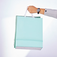 Image showing Hands, person and bag of shopping in studio, white background or fashion deal in retail product. Closeup of rich customer giving gift bags, luxury present and discount sales purchase on store credit