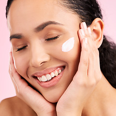 Image showing Skincare, happy and woman with face cream in studio isolated on a pink background. Smile, beauty and natural model with moisturizer, cosmetic and apply dermatology product for wellness and health