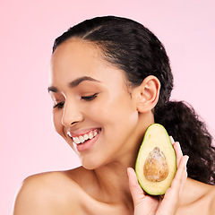 Image showing Smile, skincare and woman with avocado in studio isolated on a pink background. Happy, natural cosmetic or model with fruit, food or nutrition for healthy diet, vegan or omega 3 benefits for wellness