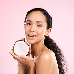 Image showing Woman, portrait and coconut fruit in beauty, healthy skincare or vegan cream on pink studio background. Face of african person, natural product and dermatology, eco friendly cosmetics or oil benefits