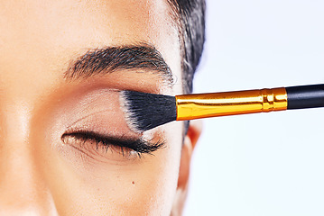 Image showing Beauty, makeup and brush with eye of woman in studio for cosmetics, product and eyeshadow. Salon, foundation and application with closeup of female model on white background for glow and self care