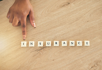 Image showing Insurance, above and hand pointing at blocks or word on a wooden table as a emergency or accident message. Medical, policy and person showing letters of safety or security for future risk management