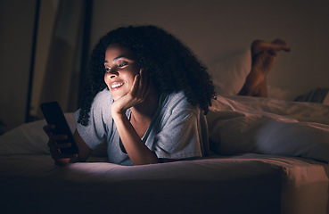 Image showing Happy woman, phone and relax in bed at night for social media, online browsing or streaming at home. Female person smile on mobile smartphone app in the dark late evening for entertainment in bedroom