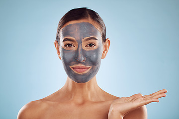 Image showing Face mask, skincare and beauty of woman showing facial product isolated in blue studio background. Skin, charcoal and person palm as advertising, branding or marketing hydration and clean dermatology