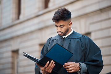 Image showing Legal, research and a lawyer man reading documents on a city street in preparation of a court case or trial. Law, study and information with a young attorney getting ready for a judgement or verdict