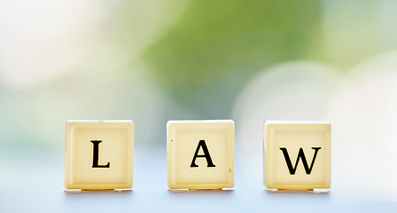 Image showing Law letter, and table with block cubes in outdoor blur with mock up space for justice or attorney. Legal, alphabet and questions for support or services in brokeh background with regulation for help.