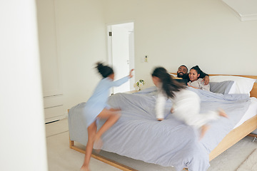 Image showing Wake up, happy family and playing in bed in the morning, bond and having fun in their home together. Love, bedroom and children jumping on parents on the weekend, playful and energetic in their house