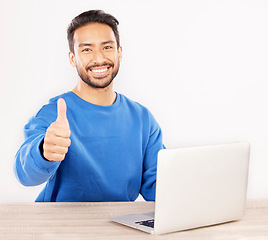 Image showing Portrait, laptop and thumbs up with an IT support man at his desk in studio on a white background. Smile, thank you and yes with a happy male computer engineer working to finish or complete a task