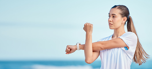 Image showing Woman, arm and stretching by beach on mockup space in fitness, motivation or outdoor workout. Female person or runner in body warm up on ocean coast, banner or sports for healthy wellness or training