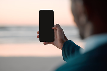 Image showing Businessman, hands and phone screen on beach for communication, advertising or outdoor networking. Closeup of man with mobile smartphone app display mockup by ocean coast for business trip or travel