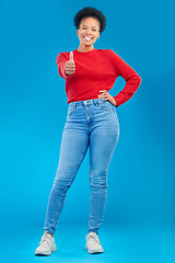 Image showing Happy woman, portrait and thumbs up for approval, winning or success against a blue studio background. Female person smile in casual fashion with like emoji, yes sign or OK for agreement or thank you