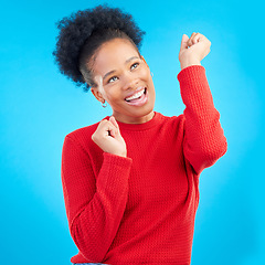 Image showing Happy woman, fist pump and celebration for winning, discount or sale against a blue studio background. Excited female person for good news, bonus promotion or lottery prize in reward or competition