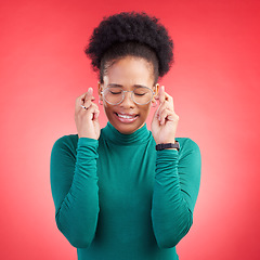 Image showing Fingers crossed, praying and black woman in studio with good luck sign for bonus, prize or giveaway on red background. Hope, wish and African lady with pray emoji for waiting, reward or lotto results