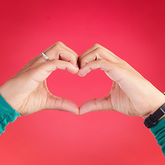 Image showing Closeup, person and heart hands for love, care or compassion against a red studio background. Hand together in loving emoji, shape or symbol for romantic gesture, icon or valentines day