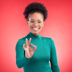 Image showing Perfect, hand and happy black woman portrait in studio for support, review or success, vote or agree on red background. Smile, face and African person with okay, emoji or yes, thank you or feedback