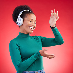 Image showing Happy, dance and black woman with music headphones in studio, freedom and good mood on red background. Podcast, radio and African female with earphone streaming, dancing and celebrating vibes