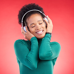 Image showing Happy black woman, headphones and listening to music for audio streaming against a red studio background. Calm African female person smile in relax enjoying sound track or entertainment on headset