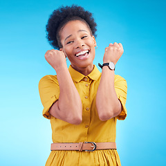 Image showing Celebration, fist and happy black woman in studio for news, deal or success on blue background. Wow, hand and excited lady winner smile for sale, discount or coming soon promo, announcement or deal