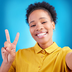 Image showing Happy woman, portrait smile and peace sign for selfie, photography or memory against a blue studio background. African female person or photographer for picture, photo or online social media post