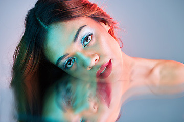 Image showing Art, reflection and beauty, portrait of woman on studio background with neon light and makeup. Fashion, skin and aesthetic, face of girl, model in creative mirror pose with cosmetics and