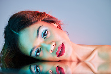 Image showing Art, reflection and beauty, portrait of woman on studio background with neon light and makeup. Fashion, skin and future aesthetic, face of girl or model in creative mirror with cosmetics and color.