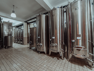 Image showing Modern wine distillery and brewery with brew kettles pipes and stainless steel tanks