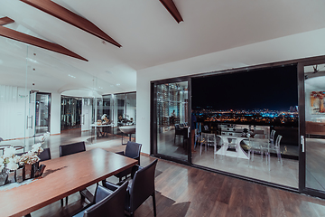 Image showing A beautiful house with a beautiful view of the night city. Luxury living room and tereasa with a view of the city. Night photo of a luxury house
