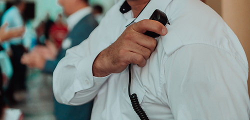 Image showing A close-up photo of a guard holding a communication device