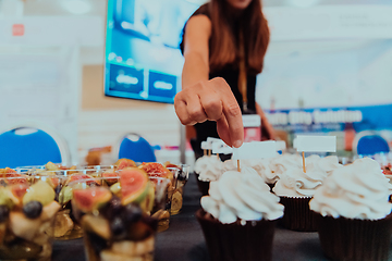 Image showing Business woman takes delicious food from the table while in the conference room