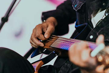 Image showing Practicing in playing guitar. Handsome young men playing guitar