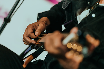 Image showing Practicing in playing guitar. Handsome young men playing guitar