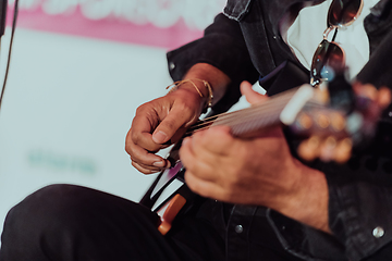 Image showing Practicing in playing guitar. Handsome young men playing guitar