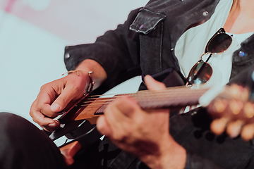 Image showing Practicing in playing guitar. Handsome young men playing guitar