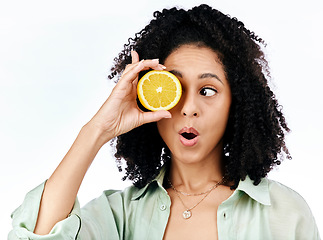 Image showing Vitamin c, lemon and eye of shocked woman with fashion for organic wellness isolated in a studio white background. Diet, fruit and healthy or excited young person with crazy citrus energy and detox