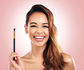 Image showing Beauty, cosmetics and portrait of woman with makeup brush on pink background for salon, wellness and luxury. Cosmetology, aesthetic and female person for foundation, eyeshadow and glamour in studio